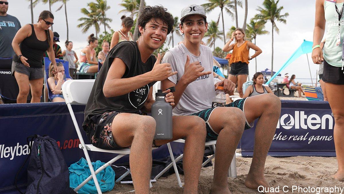 Boys giving hang loose sign at beach tournament