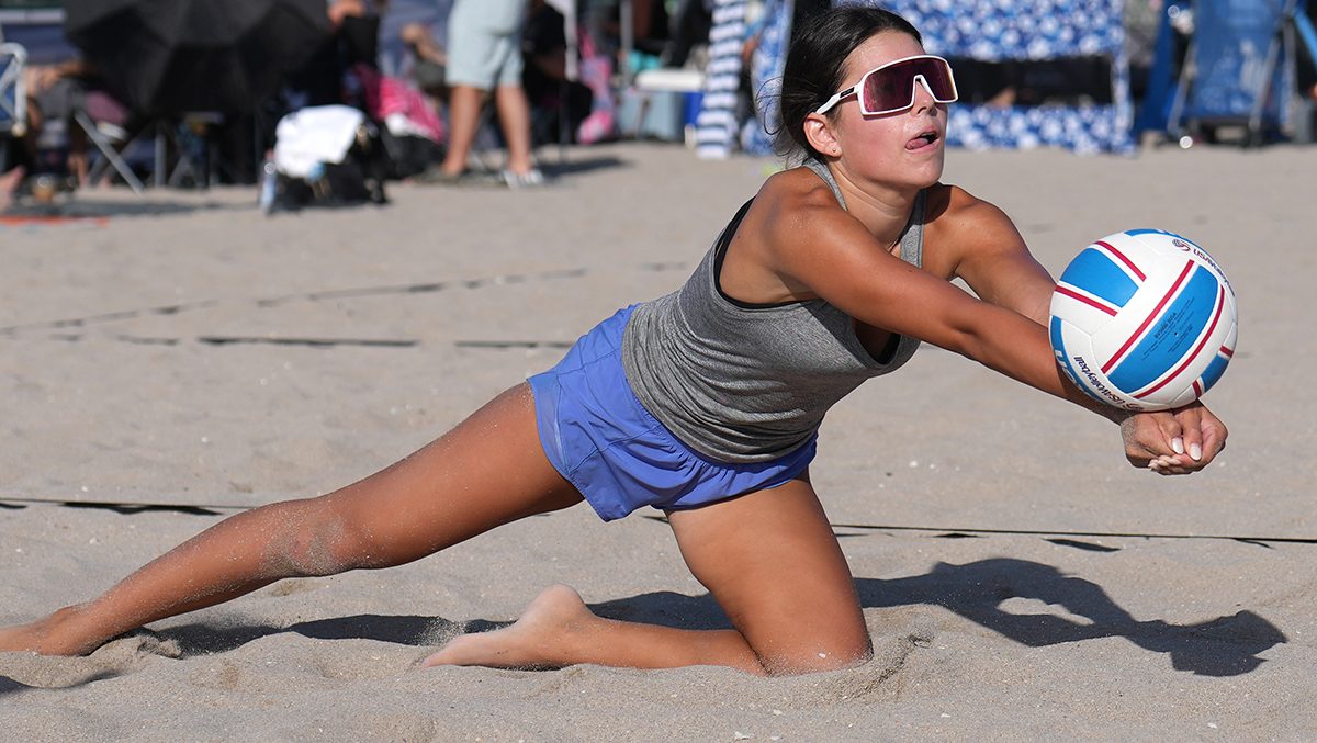 A young girl reaches out for a dig on the sand